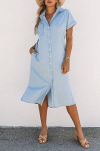 Woman flaunting her Chambray Button-Up Midi Dress at work. Lightweight Chambray Midi Dress - a wardrobe essential. Chambray Midi Dress styled with a comfy bralette. Woman looking stylish in her Chambray Button-Up Midi Dress. Trendy Chambray Midi Dress available in various designs. Casual and chic Chambray Button-Up Midi Dress.