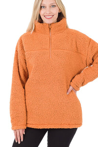 Woman wearing an orange fleece pullover on a white background