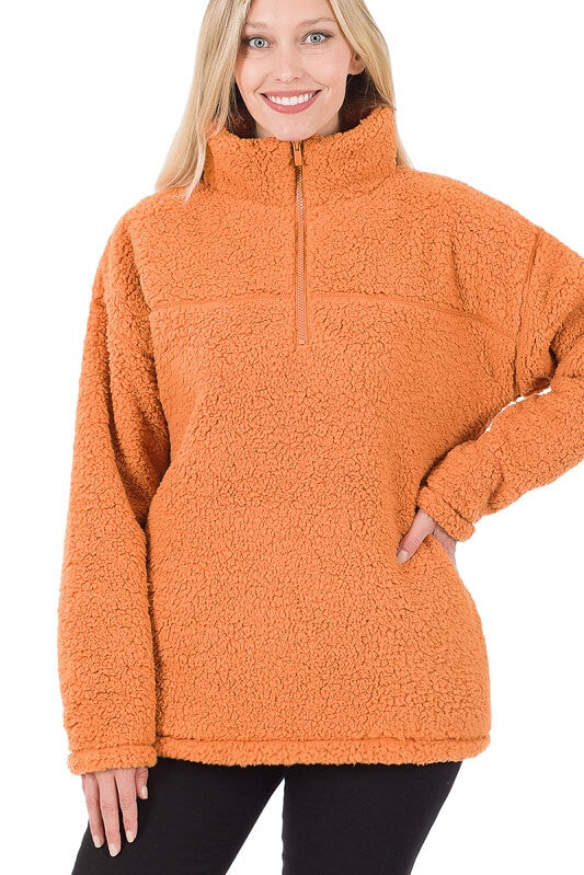 Woman wearing an orange fleece pullover on a white background
