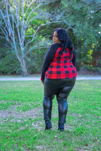 Raglan sleeve contrasting long sleeve top with red and black buffalo check print. This image features the back view of a gorgeous, plus size woman over 40 rocking this gingham print long sleeve crew neck top with a grey fringe scarf, red geometric earrings, and faux leather leggings with a pair of faux leather booties from the fall collection at Jolie Vaughan Boutique.