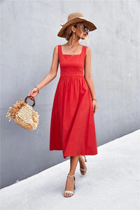 A woman wearing a red square-neck midi dress, showcasing the contemporary neckline and A-line silhouette.