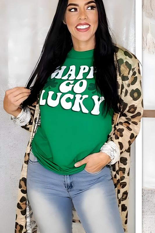 Happy woman sporting a green St. Patrick's Day T-shirt with 'HAPPY GO LUCKY' slogan, paired with a leopard print cardigan and light blue jeans